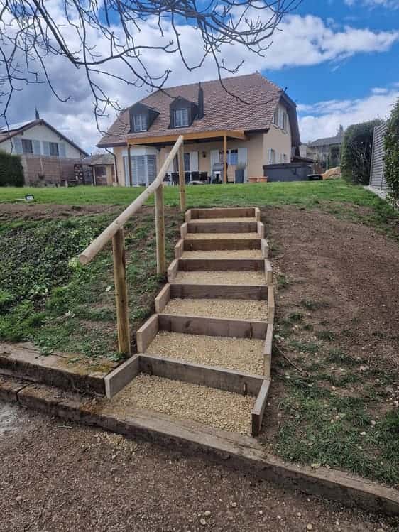 Escalier extérieur en traverses de bois dans un talus, jardin en pente sur le coteau morgien