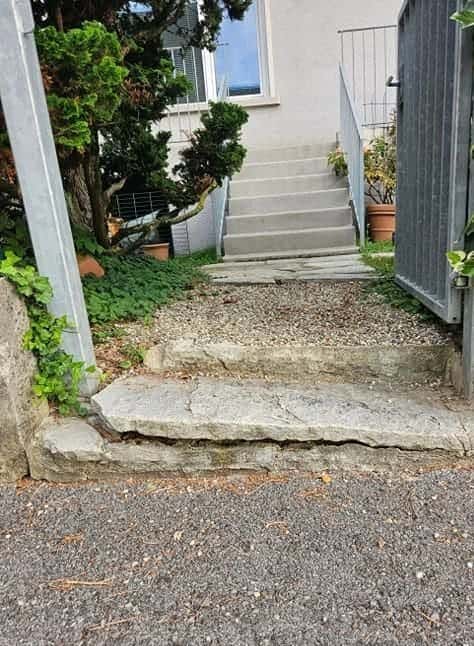Accès en gravier et marche instable, repris en dallage de plain-pied, avant intervention